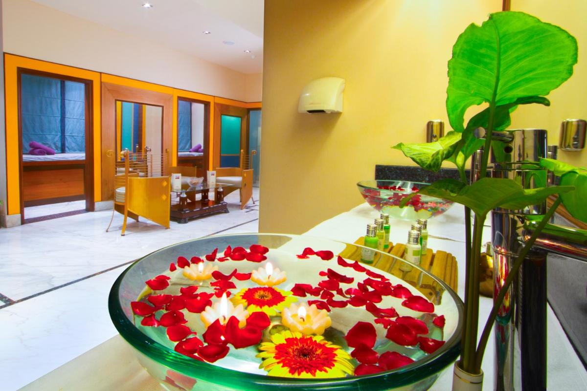 a plate of flowers on a table in a room at The Piccadily in Lucknow
