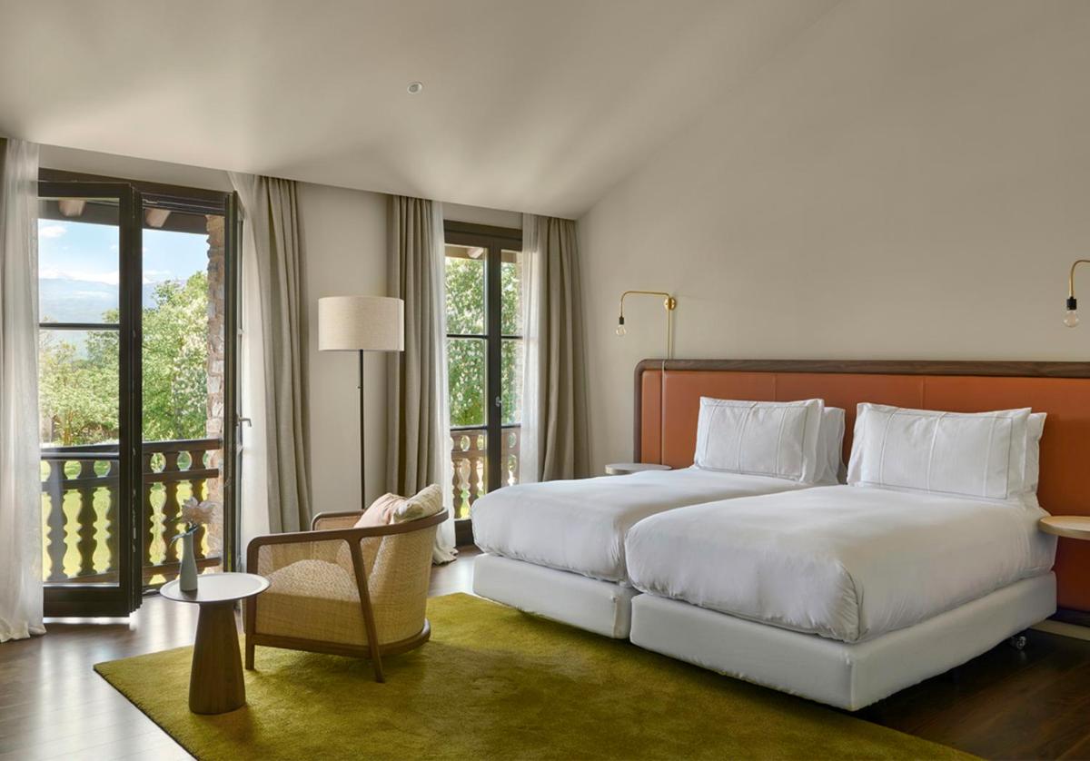 Un dormitorio con una cama grande y un balcón. en Torre del Remei, en Bolvir