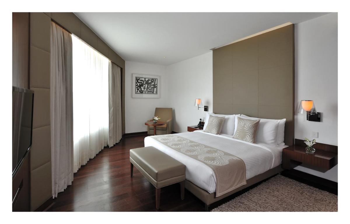 a bedroom with a large bed and a large window at The Anya Hotel-Golf Course Road in Gurgaon