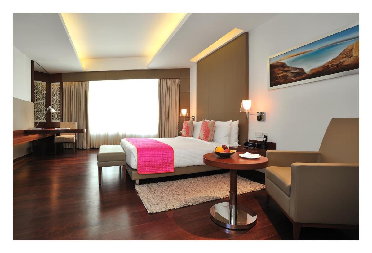 a hotel room with a bed and a couch at The Anya Hotel-Golf Course Road in Gurgaon