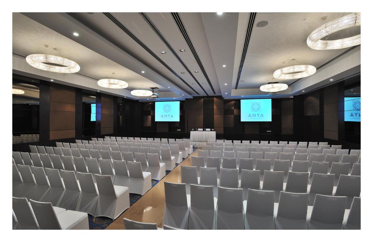 an empty lecture hall with chairs and two screens at The Anya Hotel-Golf Course Road in Gurgaon