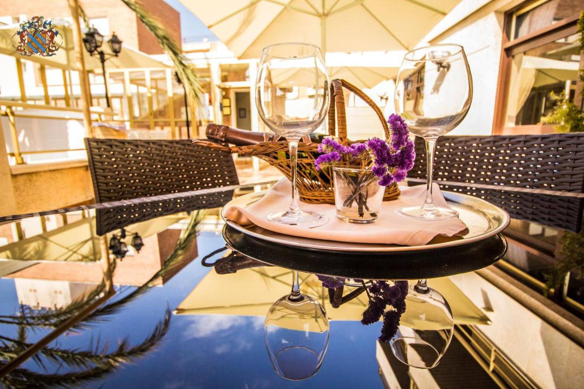una mesa con dos copas de vino y flores en ella en Hotel Victoria Spa & Splay Center, en Segur de Calafell