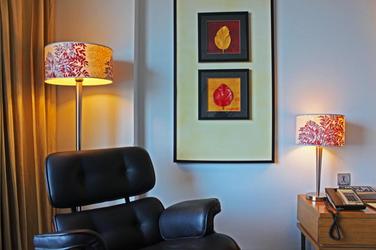 a hotel room with a chair and two lamps at Fortune Select SG Highway, Ahmedabad - Member ITC Hotels' Group in Ahmedabad
