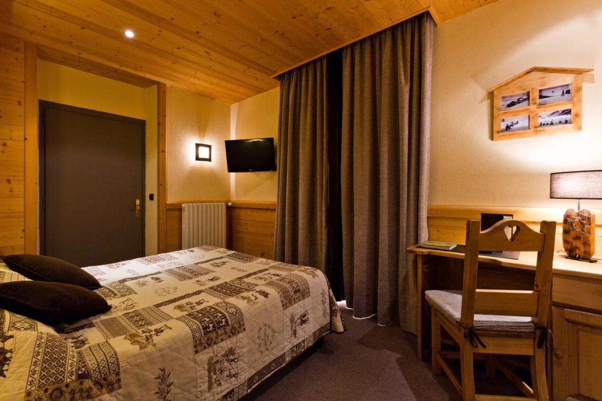 une chambre avec un lit, un bureau et une chaise dans l'établissement Logis Hotel & Spa Beau-Site, à Saint-Jean-de-Sixt 68 autres photos
