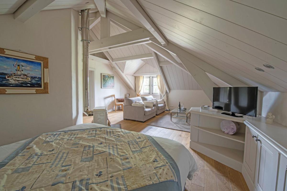 une chambre avec un lit et un salon dans l'établissement Villa Cécile, à Yvoire