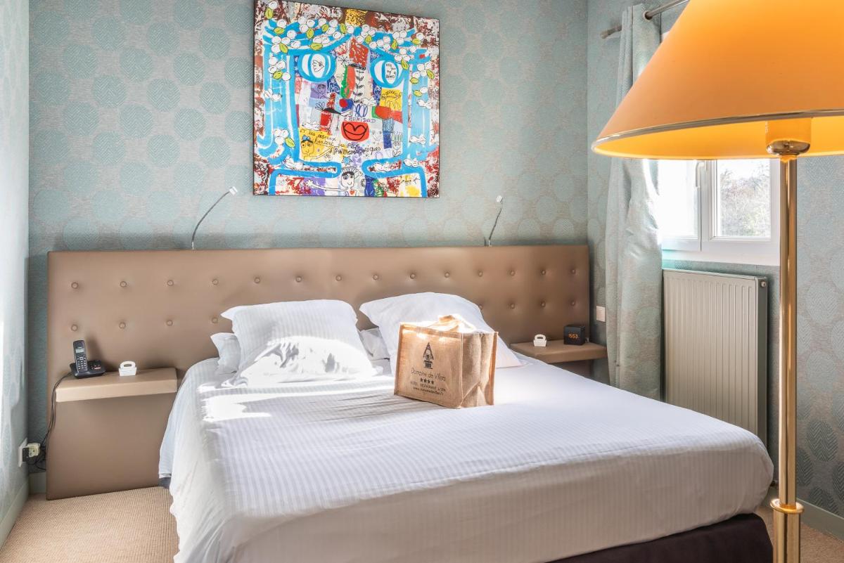 une chambre avec un lit avec un sac dessus dans l'établissement Domaine De Villers & Spa, à Villers-sur-Mer