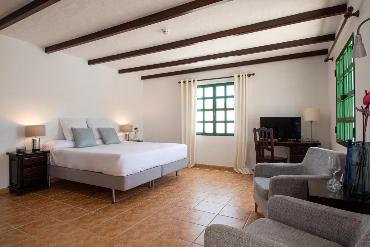 Un dormitorio con una cama, un sofá y un televisor. en Casas Heddy, Well-being Resort, en Puerto del Carmen