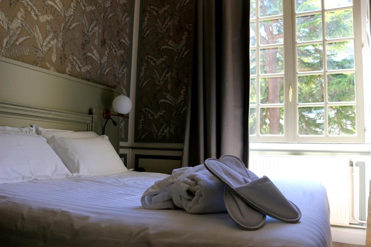 Un ou plusieurs lits dans un hébergement de l'établissement Hôtel Anne d'Anjou, The Originals Collection