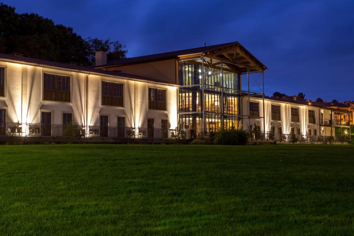 un gran edificio blanco con césped por la noche en Eurostars Vila de Allariz Hotel Balneario, en Allariz