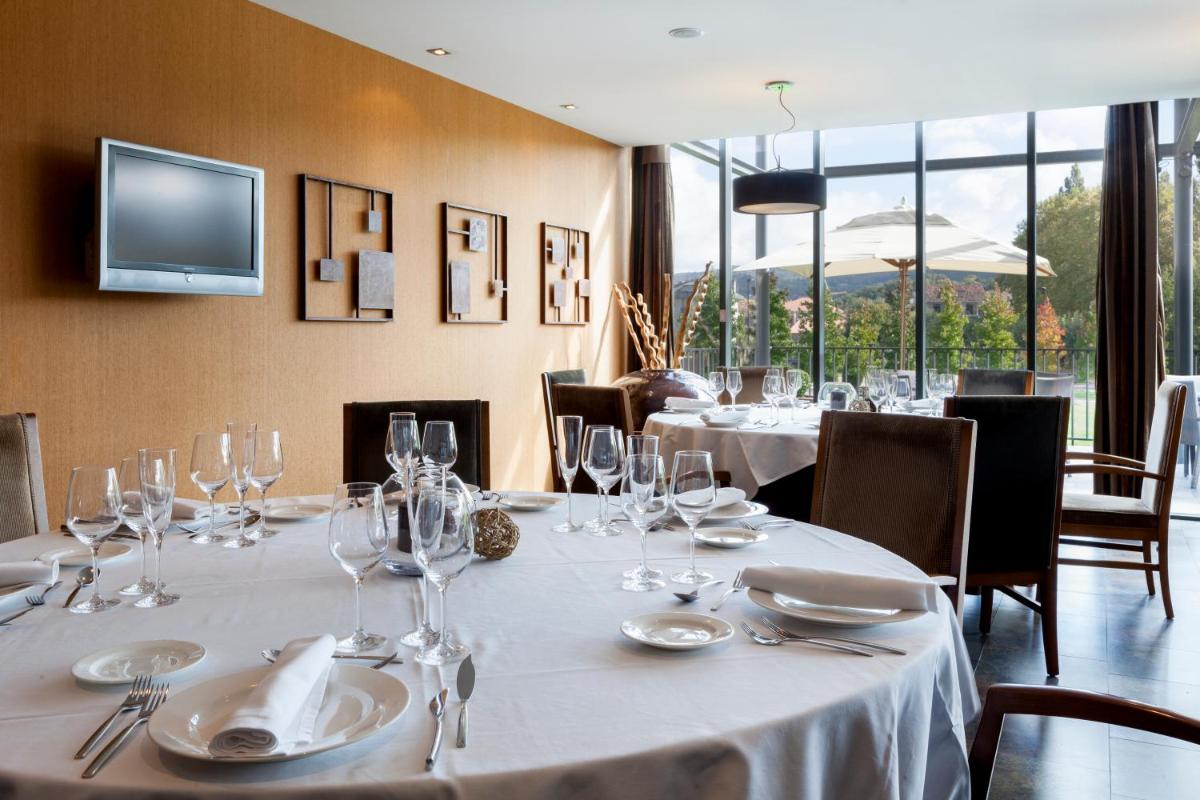 comedor con mesas con copas de vino y TV en Eurostars Vila de Allariz Hotel Balneario, en Allariz