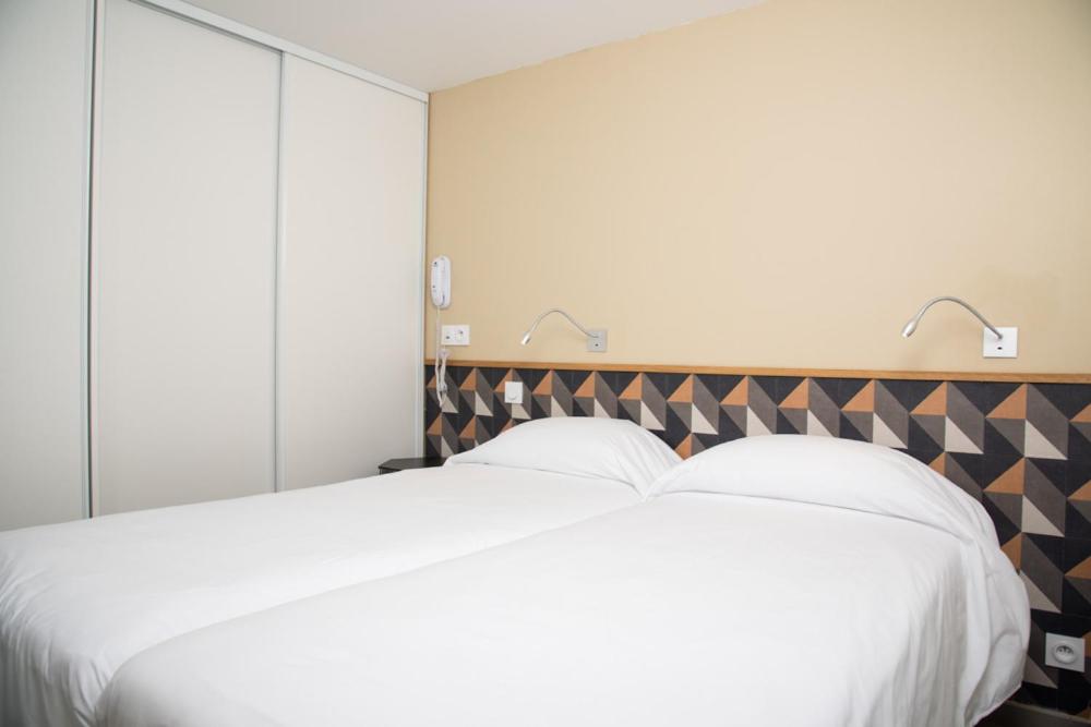 Un ou plusieurs lits dans un hébergement de l'établissement Hotel Les Dunes