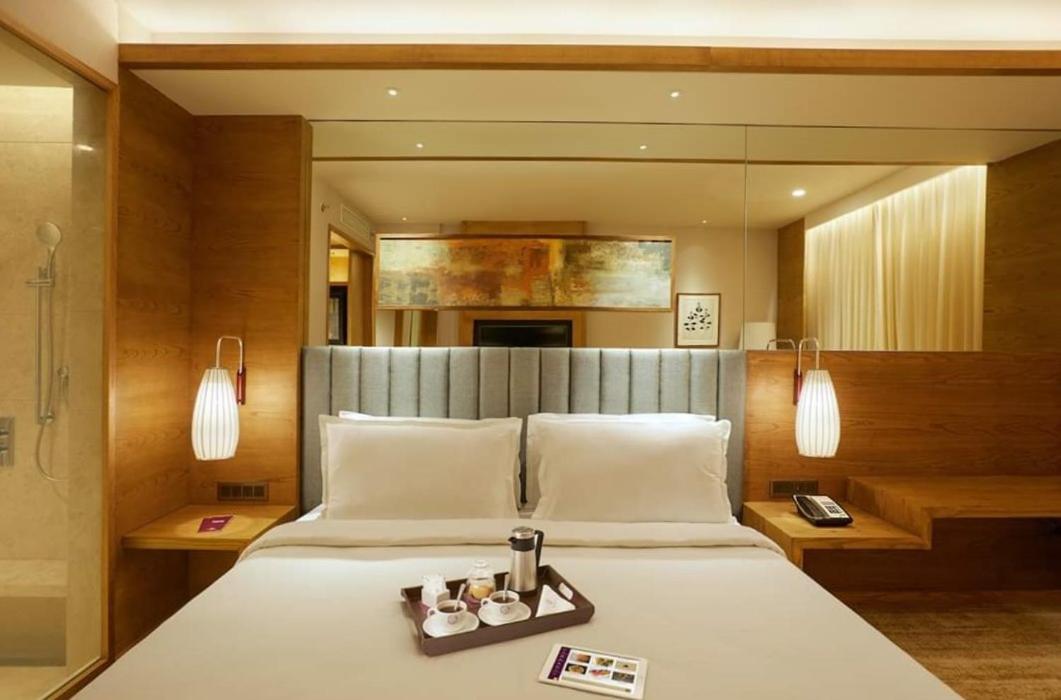 a bedroom with a bed with a tray of candles on it at The Residency Towers Puducherry in Puducherry