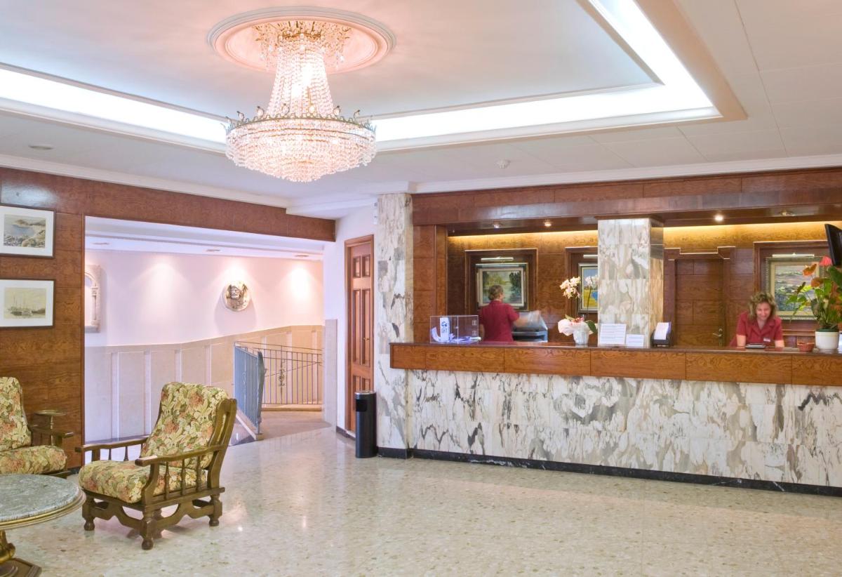 vestíbulo del hotel con mostrador de recepción y lámpara de araña en Hotel GHT Neptuno-Tossa & Venus SPA, en Tossa de Mar 100 fotos más