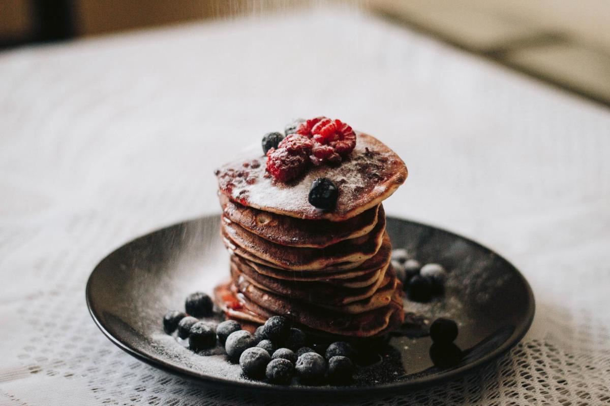 a plate with a stack of pancakes with berries on it at Park Hyatt Hotel and Residences, Hyderabad in Hyderabad