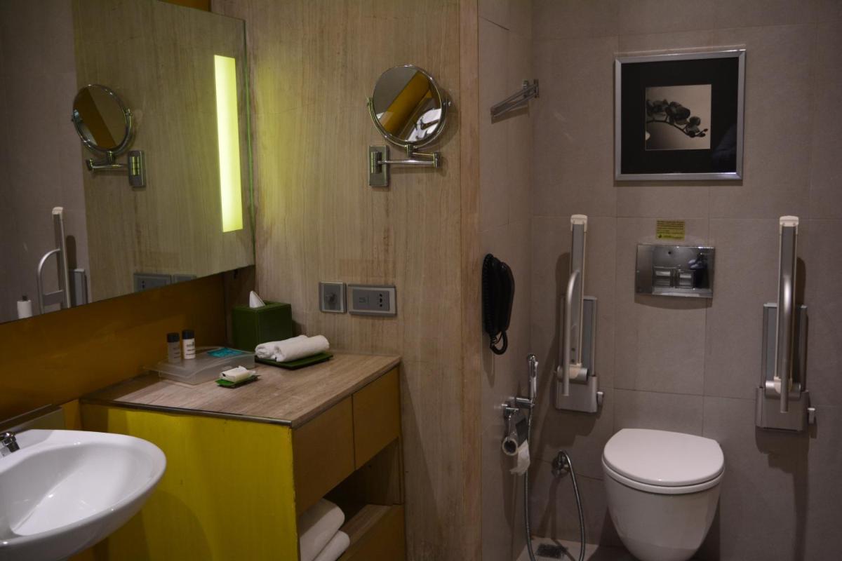 a bathroom with a sink and a toilet and a mirror at Holiday Inn New Delhi Aerocity by IHG in New Delhi