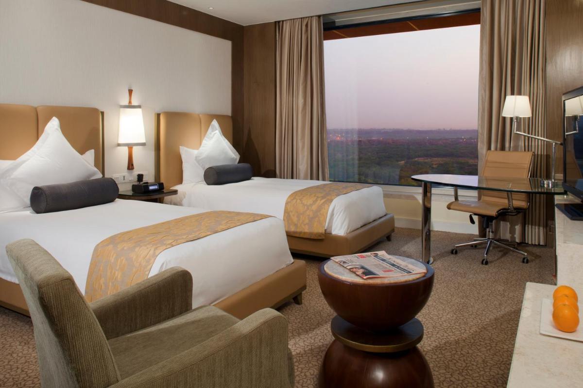 a hotel room with two beds and a table at Crowne Plaza New Delhi Okhla by IHG in New Delhi