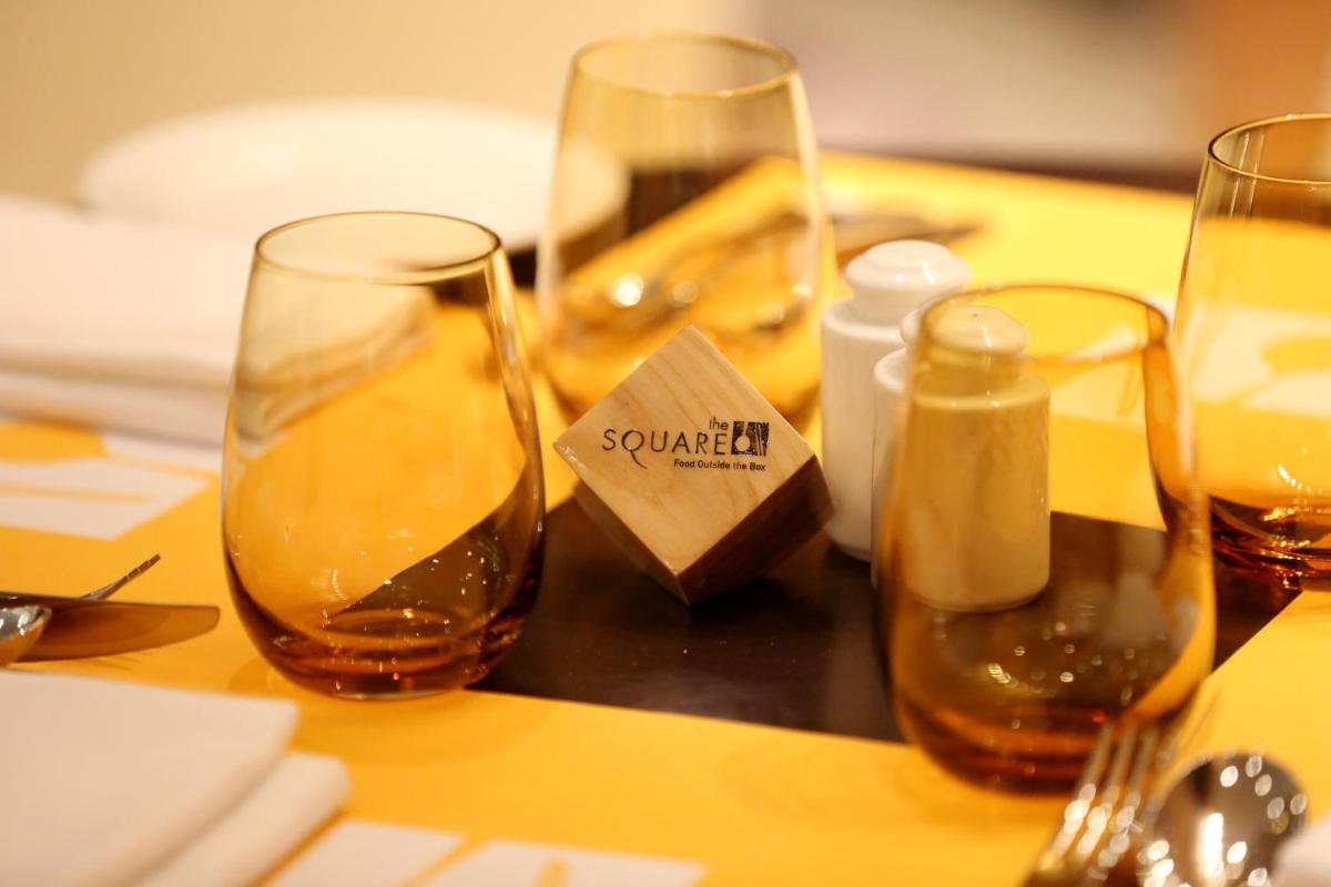 a table with three wine glasses on a table at Novotel Pune Viman Nagar Road in Pune