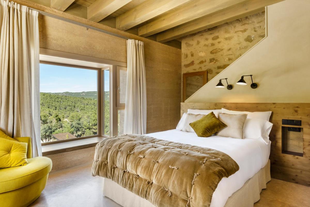 Un dormitorio con una cama grande y una ventana grande. en Torre del Marqués Hotel Spa & Winery - Small Luxury Hotels, en Monroyo