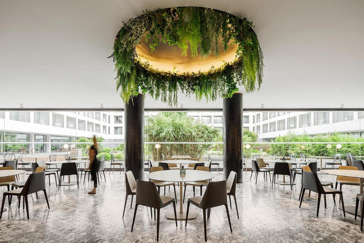um restaurante com mesas e cadeiras em um prédio em Azoris Royal Garden – Leisure & Conference Hotel em Ponta Delgada