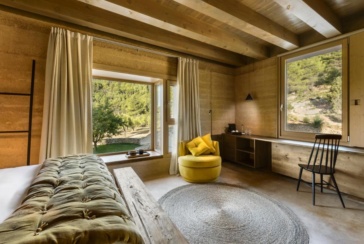 Un dormitorio con una cama grande y una ventana grande. en Torre del Marqués Hotel Spa & Winery - Small Luxury Hotels, en Monroyo