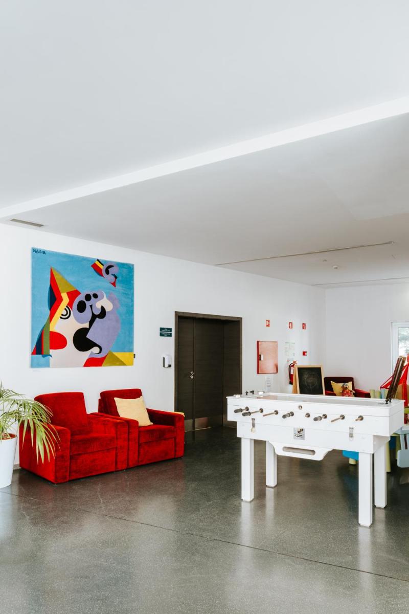 uma sala de estar com um sofá vermelho e uma mesa de pingue-pongue em Boticas Hotel Art & SPA em Boticas