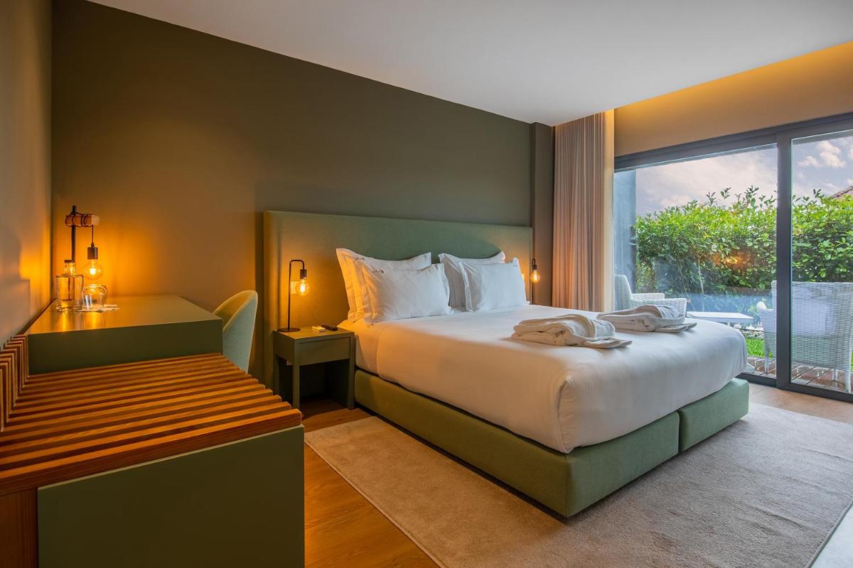 um quarto com uma cama grande e uma janela em Quinta do Pedregal Hotel & Spa em Vila Nova de Gaia mais 83 fotografias
