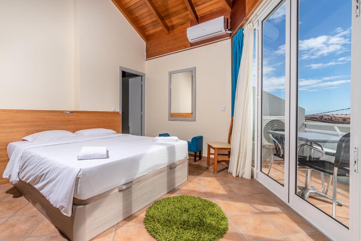 um quarto com uma cama e uma varanda em TarmarPlace em Jardim do Mar