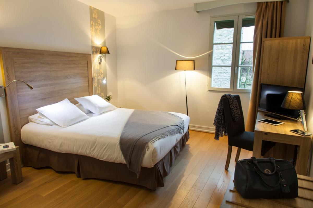 une chambre d'hôtel avec un lit et un bureau avec un ordinateur dans l'établissement Logis Hostellerie des Clos et restaurant Bistrot des grands crus, à Chablis