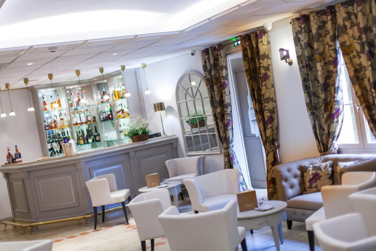 - un bar avec des chaises, un canapé et des tables dans l'établissement Logis Hostellerie des Clos et restaurant Bistrot des grands crus, à Chablis