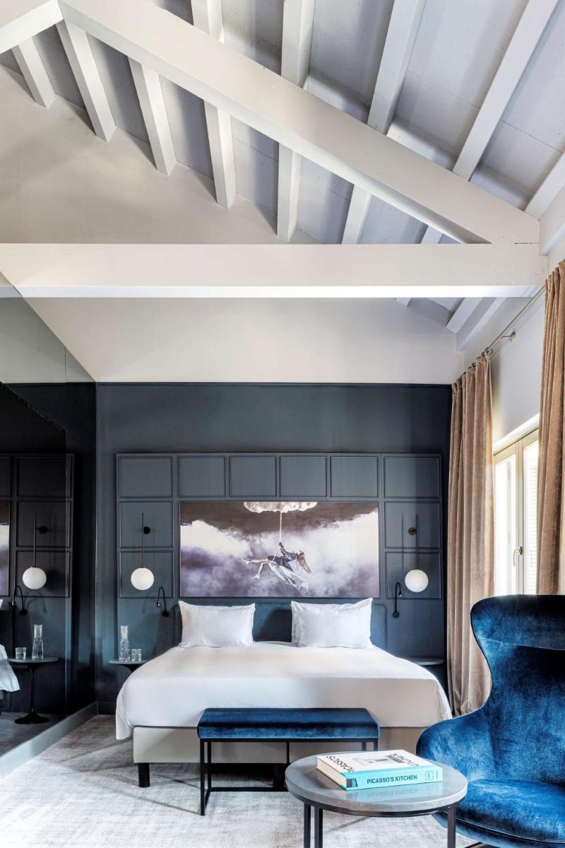 Un dormitorio con una cama grande y una silla azul. en Radisson Blu Hotel, Madrid Prado, en Madrid 85 fotos más