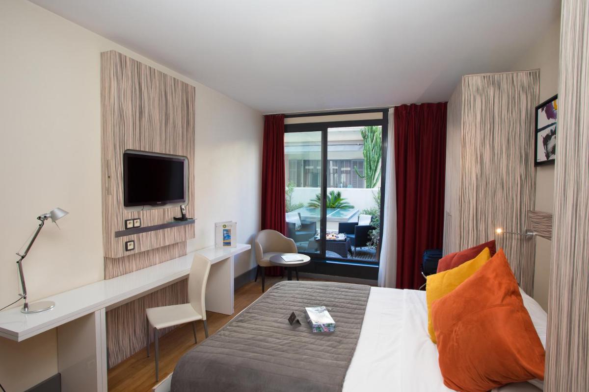 une chambre d'hôtel avec un lit et une télévision dans l'établissement Eden Hotel & Spa, à Cannes