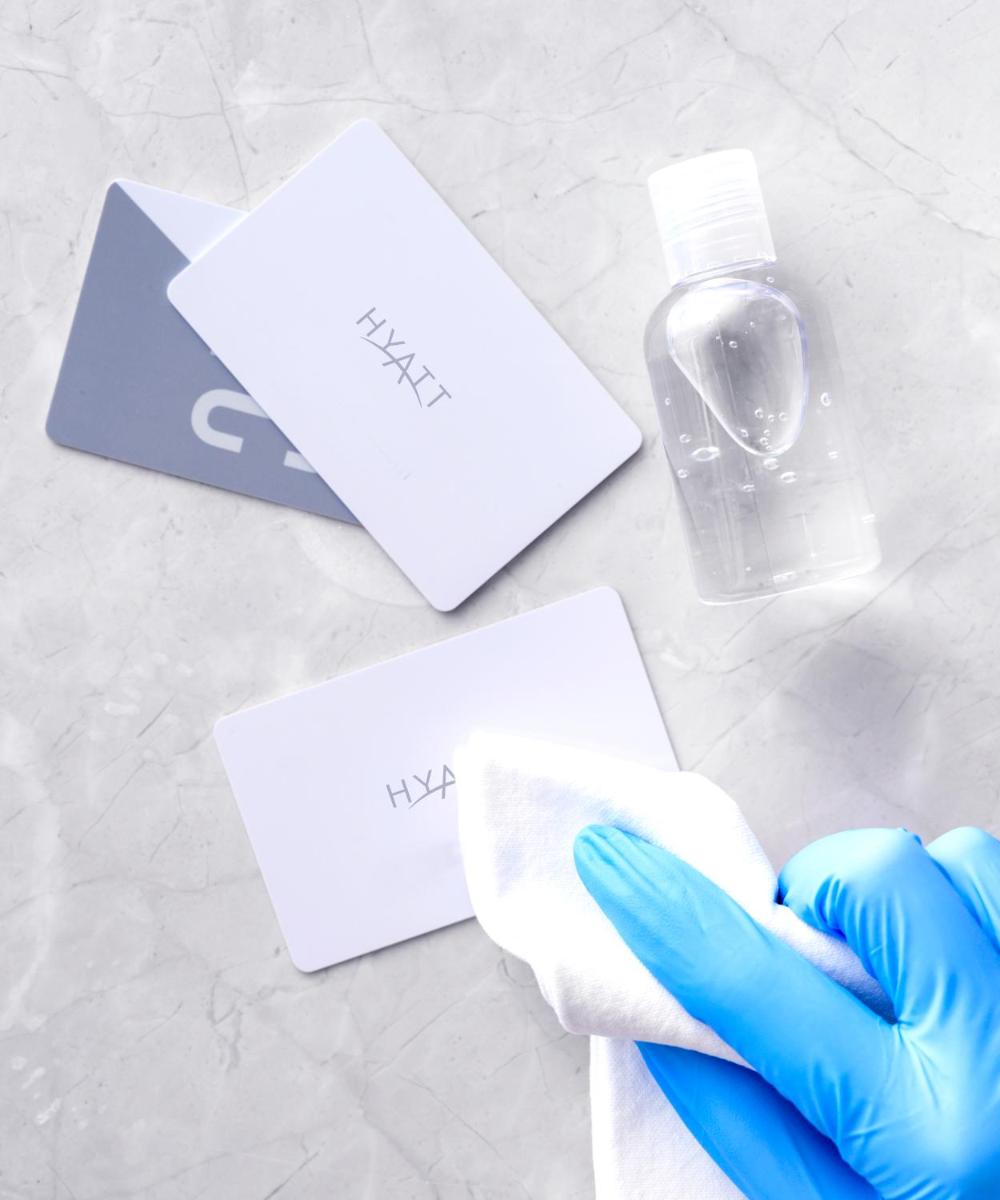 a person in blue gloves holding a bottle and a towel at Hyatt Regency Kolkata in Kolkata a person in blue gloves holding a bottle and a towel at Hyatt Regency Kolkata in Kolkata