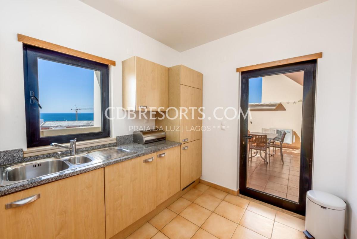 um quarto com uma cozinha com vista para o oceano em Estrela da Luz Resort na Praia da Luz