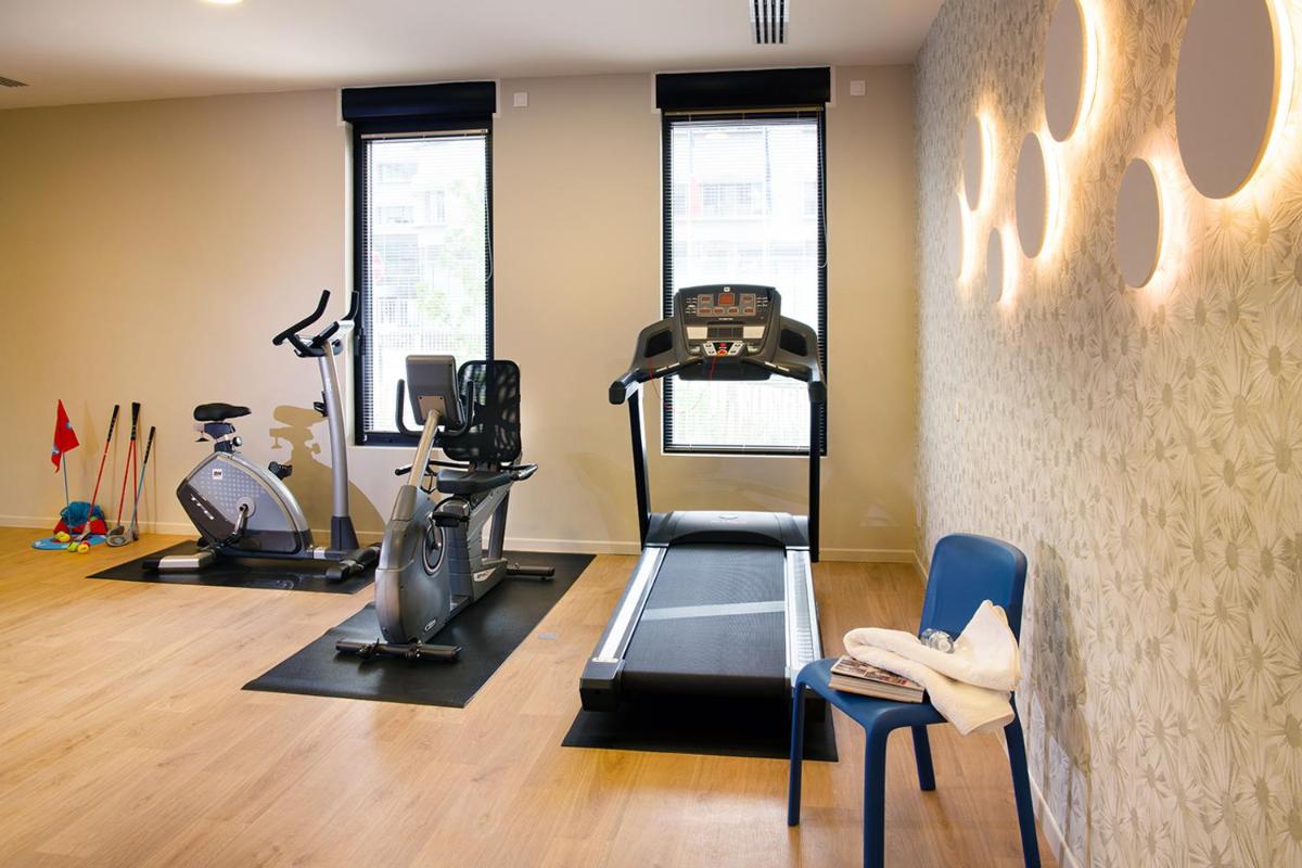 une salle de sport avec tapis roulant et appareils de musculation dans l'établissement Domitys - Galilée, à Cergy