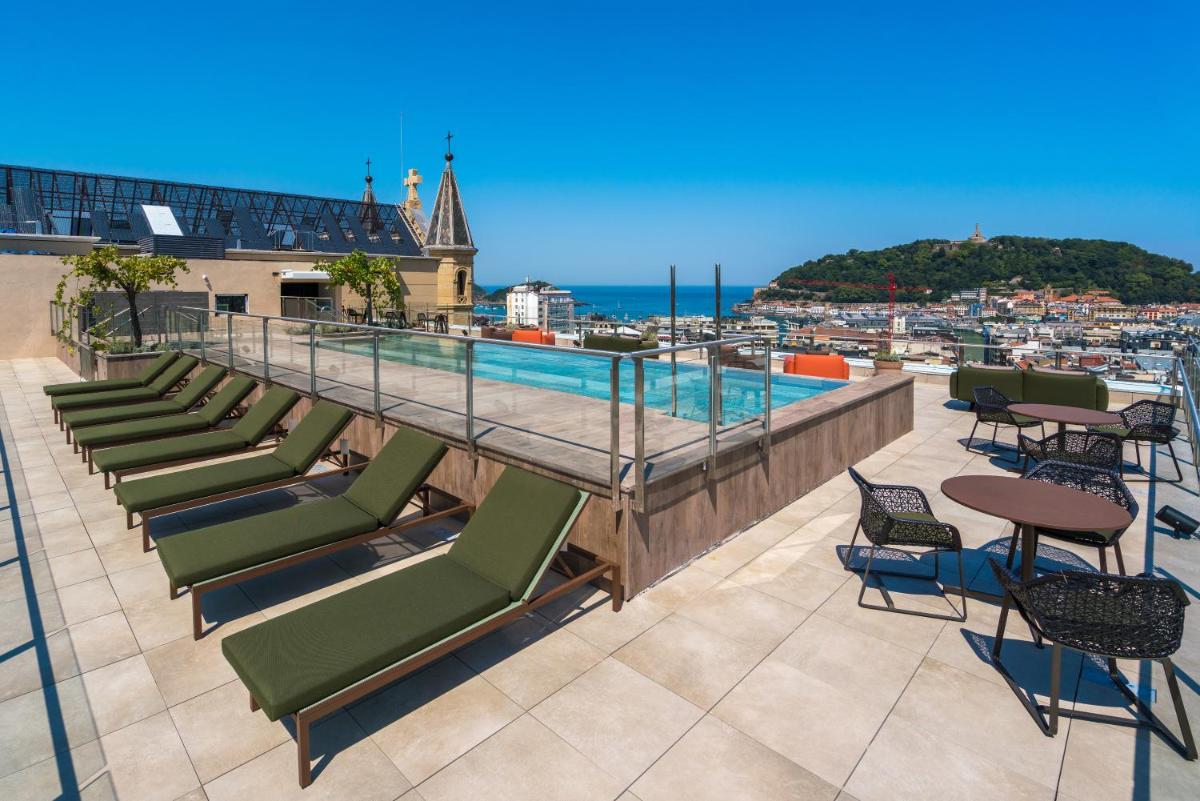 un patio en la azotea con sillas y una piscina en Catalonia Donosti, en San Sebastián