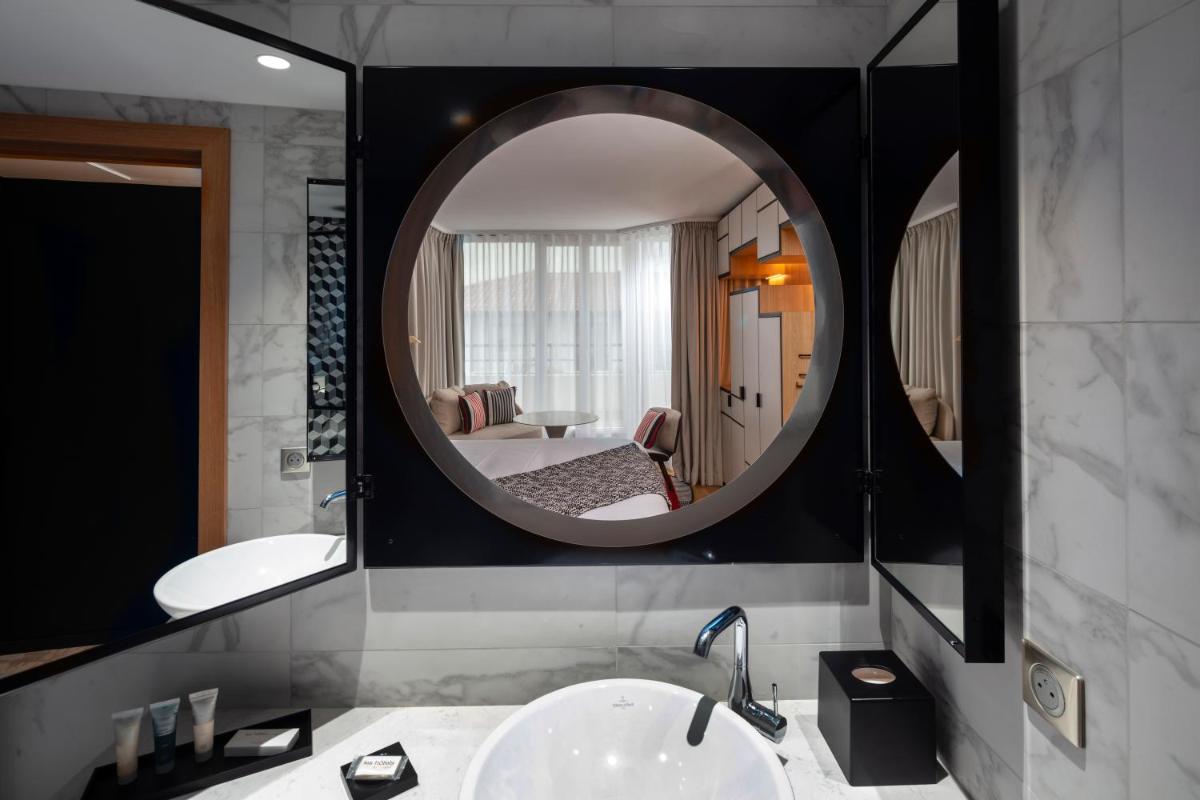 une salle de bain avec un lavabo et un miroir dans l'établissement Thalazur Saint Jean de Luz - Hôtel & Spa, à Saint-Jean-de-Luz