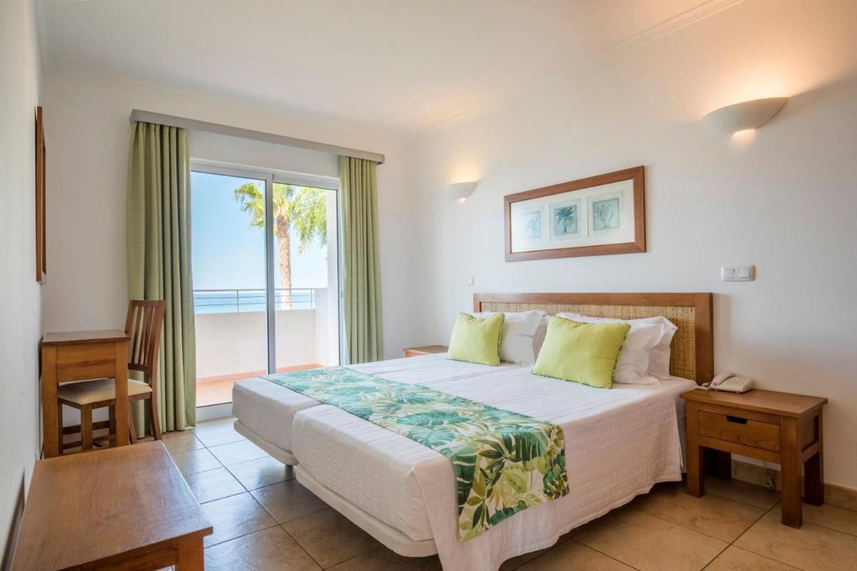 um quarto com uma cama e uma janela grande em Clube Porto Mos - Sunplace Hotels & Beach Resort em Lagos