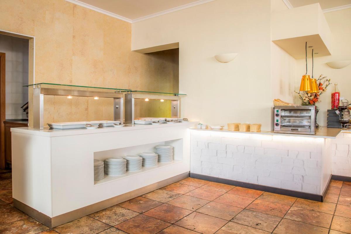 uma cozinha com um balcão com pratos em Clube Porto Mos - Sunplace Hotels & Beach Resort em Lagos