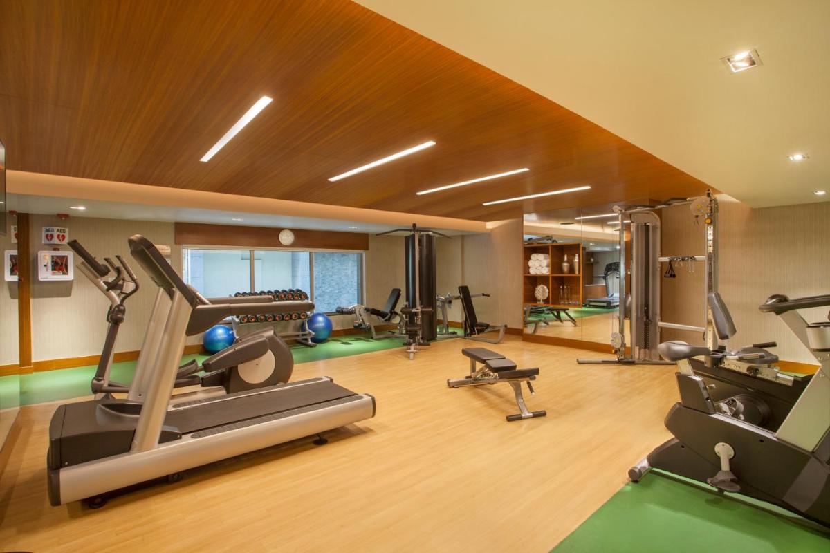 a gym with several treadmills and exercise equipment at Hyatt Place Hyderabad Banjara Hills in Hyderabad