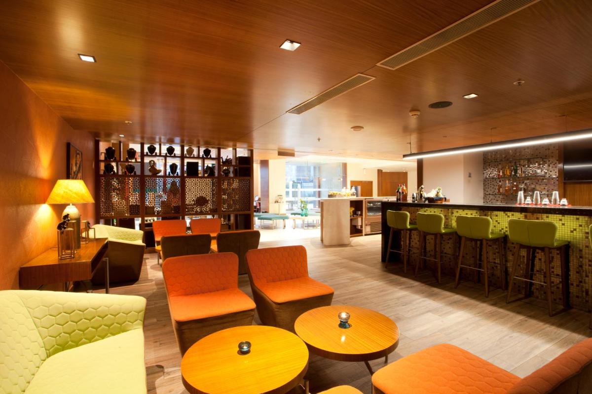 a restaurant with tables and chairs and a bar at Hyatt Place Hyderabad Banjara Hills in Hyderabad