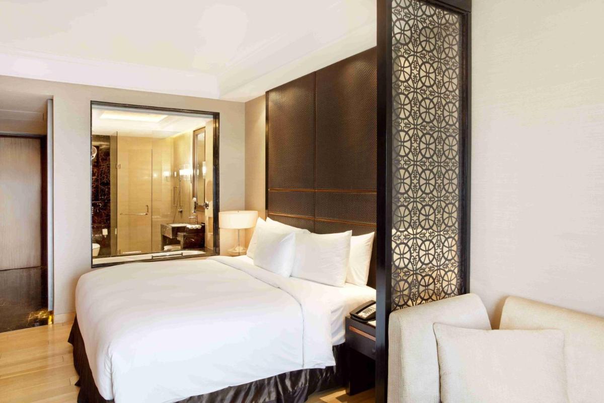 a bedroom with a large white bed and a mirror at Crowne Plaza New Delhi Mayur Vihar Noida by IHG in New Delhi
