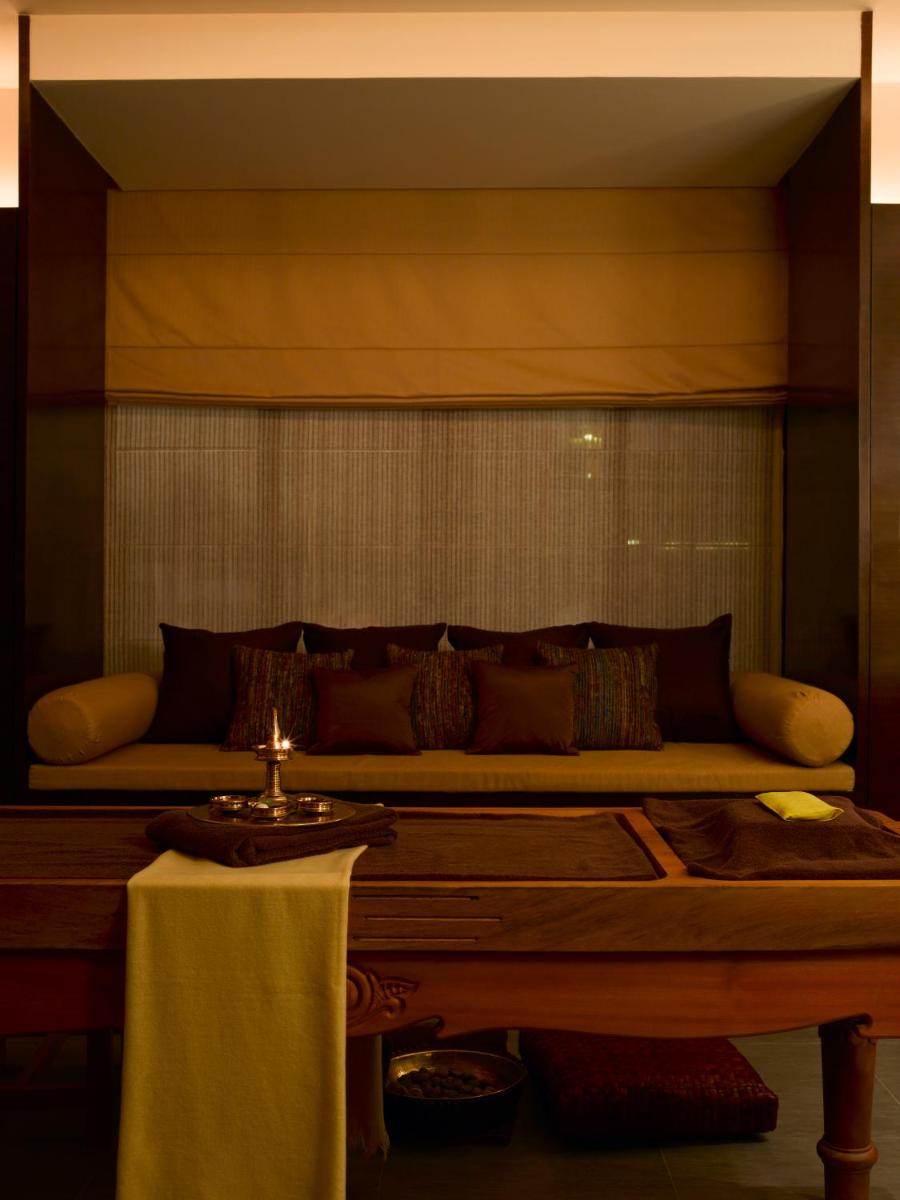 a large bed in a room with a table at Hyatt Hyderabad Gachibowli in Hyderabad