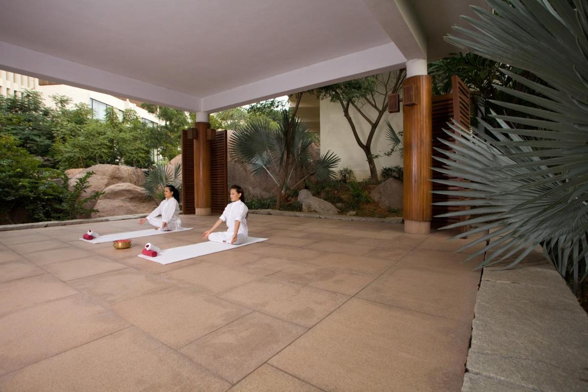 two children are sitting on mats on a patio at Hyatt Hyderabad Gachibowli in Hyderabad