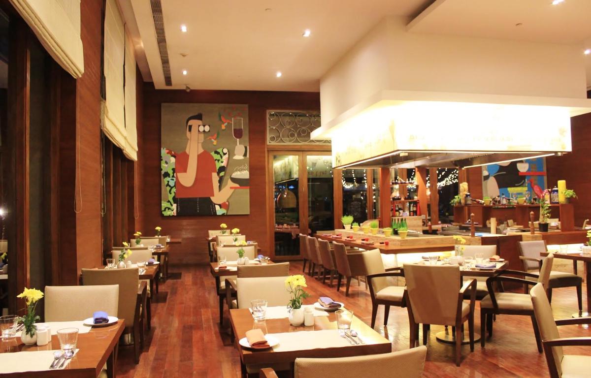a dining room with tables and chairs in a restaurant at Hyatt Hyderabad Gachibowli in Hyderabad