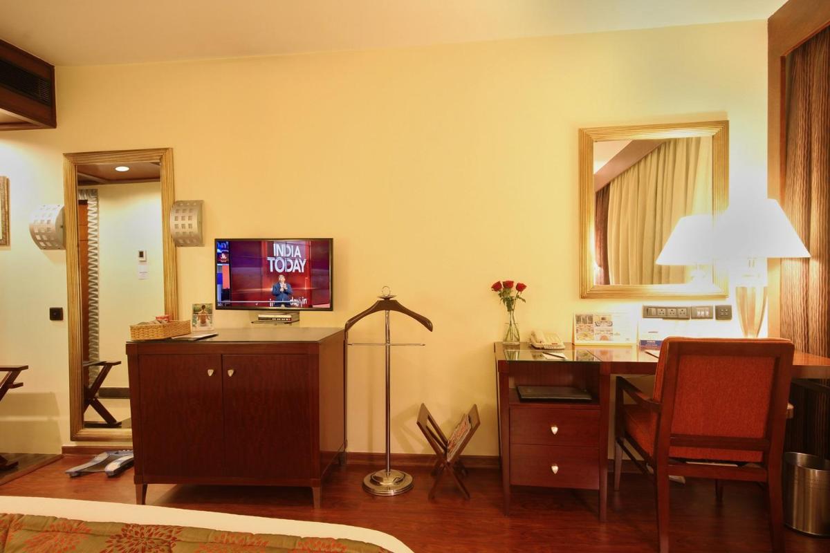 a living room with a desk with a television on it at Fortune Select JP Cosmos, Bengaluru - Member ITC Hotels' Group in Bengaluru
