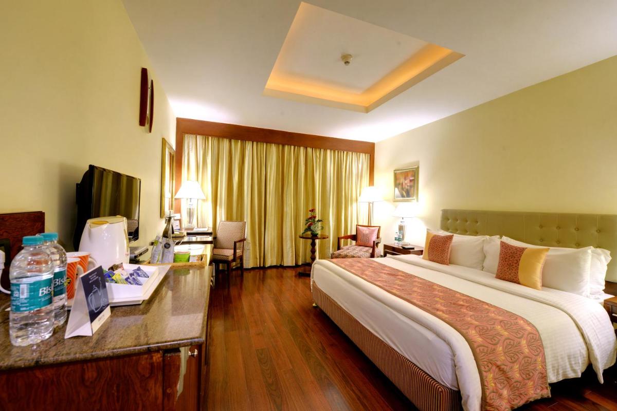 a hotel room with a large bed and a desk at Fortune Select JP Cosmos, Bengaluru - Member ITC Hotels' Group in Bengaluru