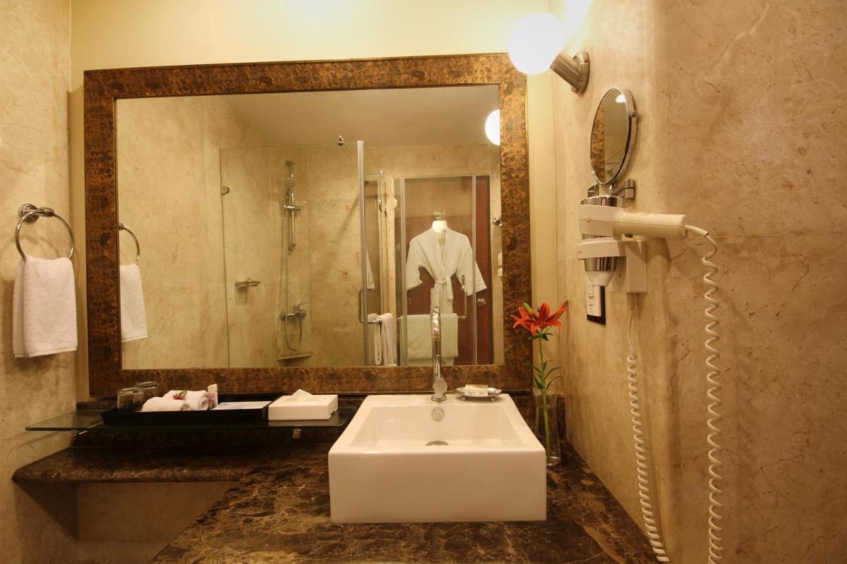a bathroom with a sink and a large mirror at Fortune Select JP Cosmos, Bengaluru - Member ITC Hotels' Group in Bengaluru