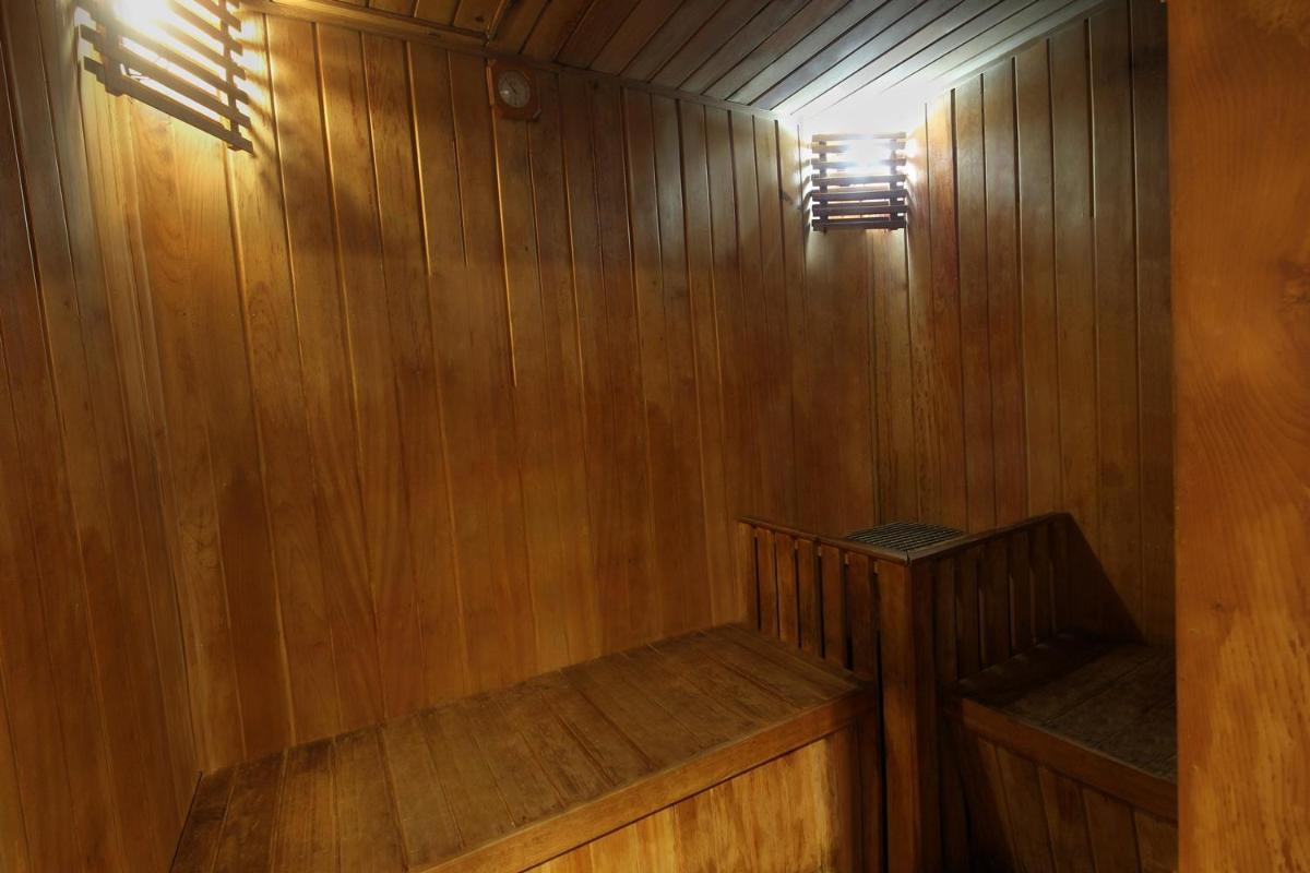 a wooden sauna with two wooden benches in it at Fortune Select JP Cosmos, Bengaluru - Member ITC Hotels' Group in Bengaluru
