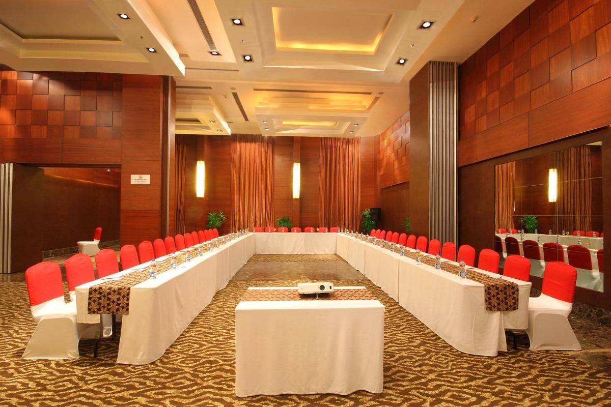 a large conference room with tables and red chairs at Fortune Select JP Cosmos, Bengaluru - Member ITC Hotels' Group in Bengaluru