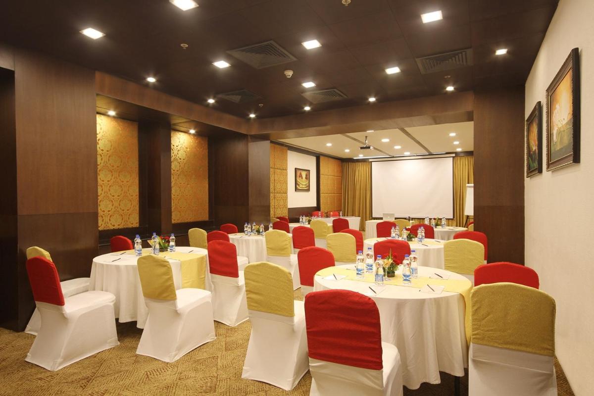 a conference room with white tables and red and yellow chairs at Fortune Select JP Cosmos, Bengaluru - Member ITC Hotels' Group in Bengaluru